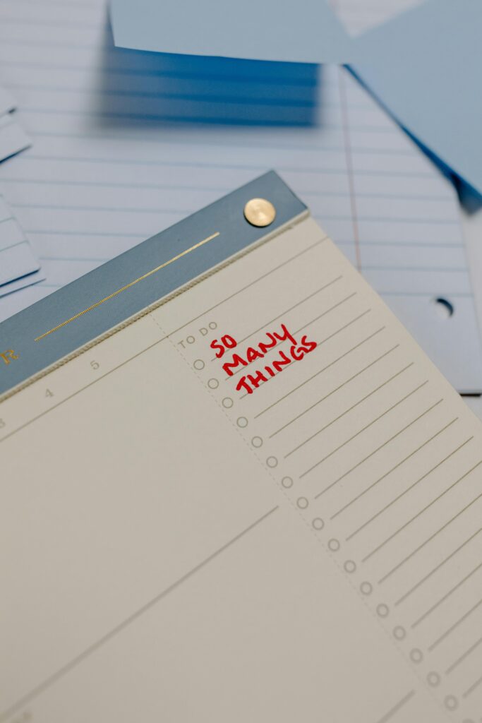 A planner with 'So Many Things' written, surrounded by loose notes.