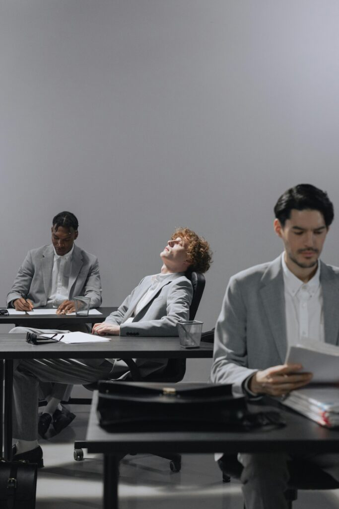 Professionals in office experiencing work fatigue, highlighting burnout.
